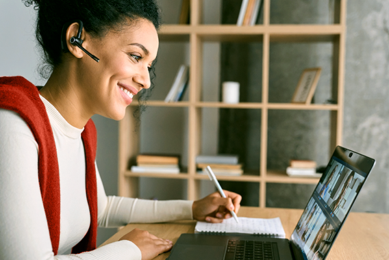 Vrouw die een online trainingssessie volgt op haar laptop