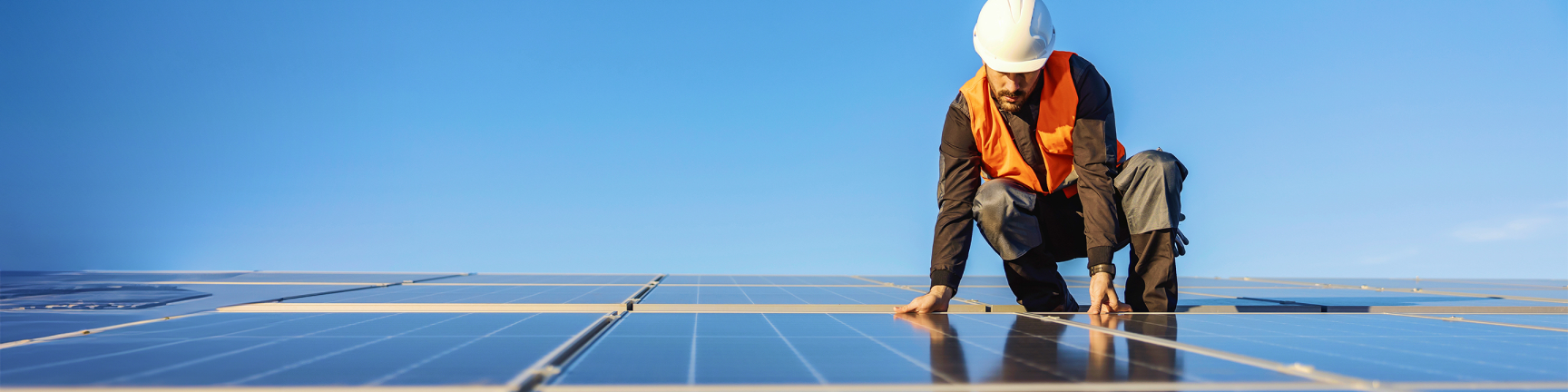 Man met helm op zonnepanelen