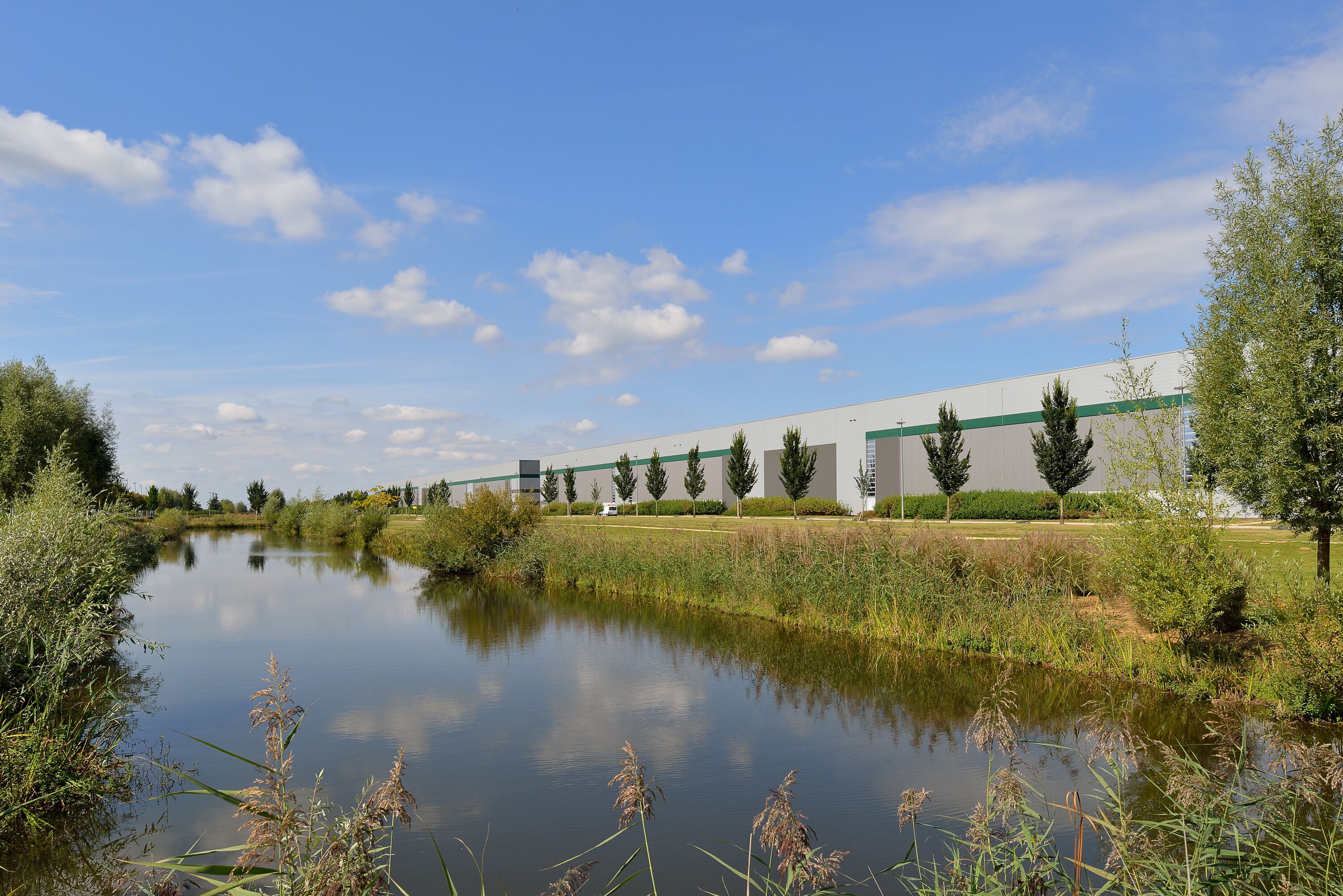 Een warehouse met bomen en een rivier in de omgeving