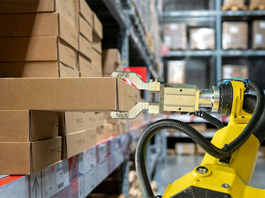 Yellow robot arm in warehouse